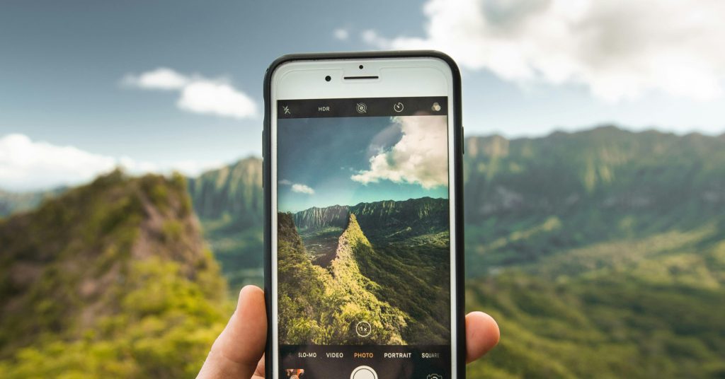person taking photo of mountains