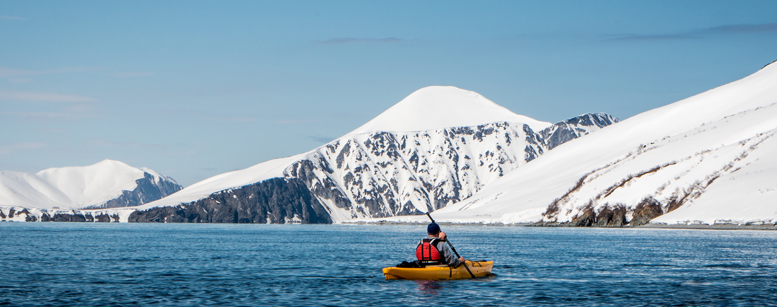 kayaking in water with snow mountains