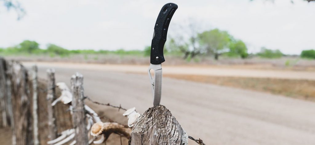 Closeup of knife in wood post.