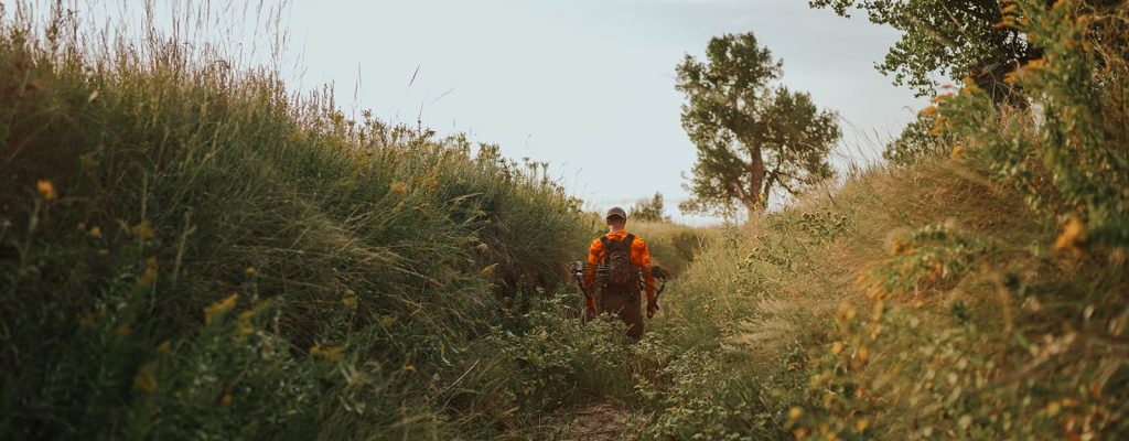 man walking through high grass