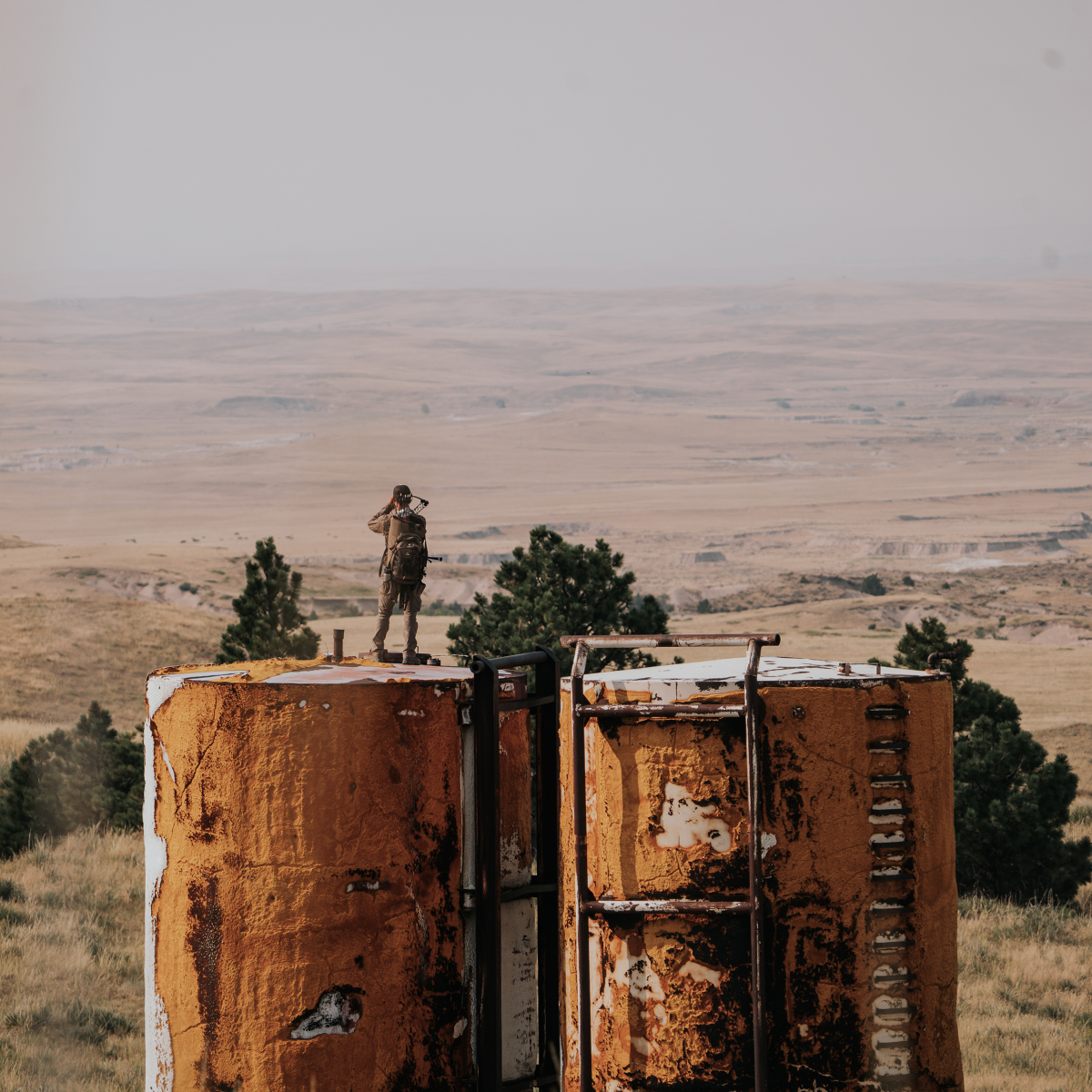 Standing on tall storage tanks in dessert