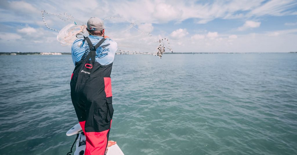 man throwing cast net