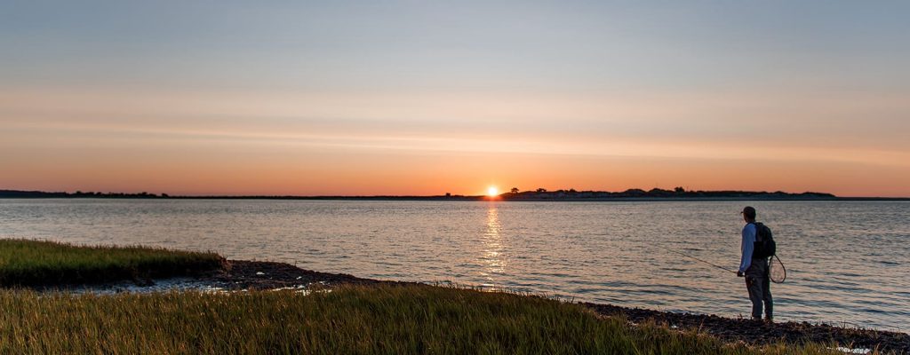 Man fishing at sunset.