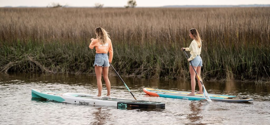 Two women paddleboating.