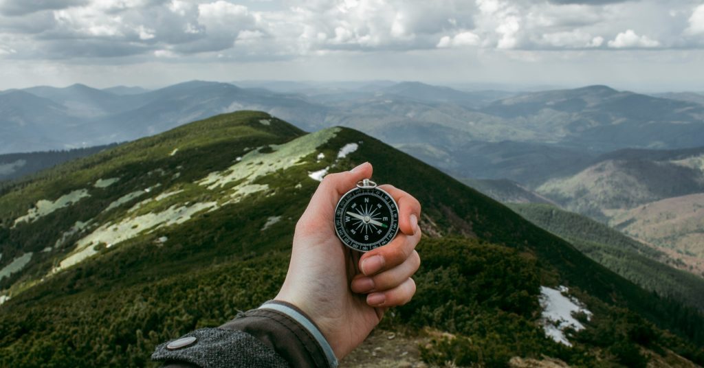 holding a compass on mountain