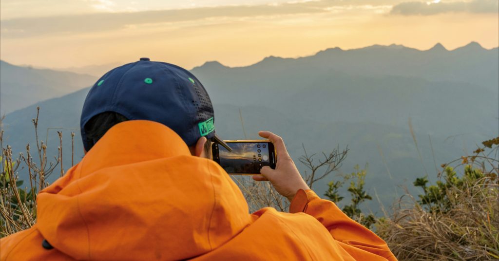 person taking photo of mountains